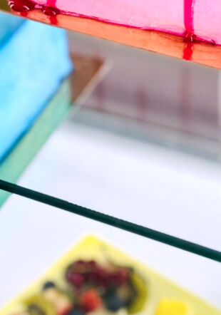 C'est un part de gateau sur une vitrine. Avec un coulis de fruits rouge, le gateau est rose. © Magali Dougados